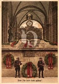 Recto carte postale ancienne deux gardes SS devant le mémorial de Munich des morts du  putch le 9 Novembre 1923 avec des couronnes de fleurs et ruban rouge dessus il est inscrit Adolf Hitler et swastika